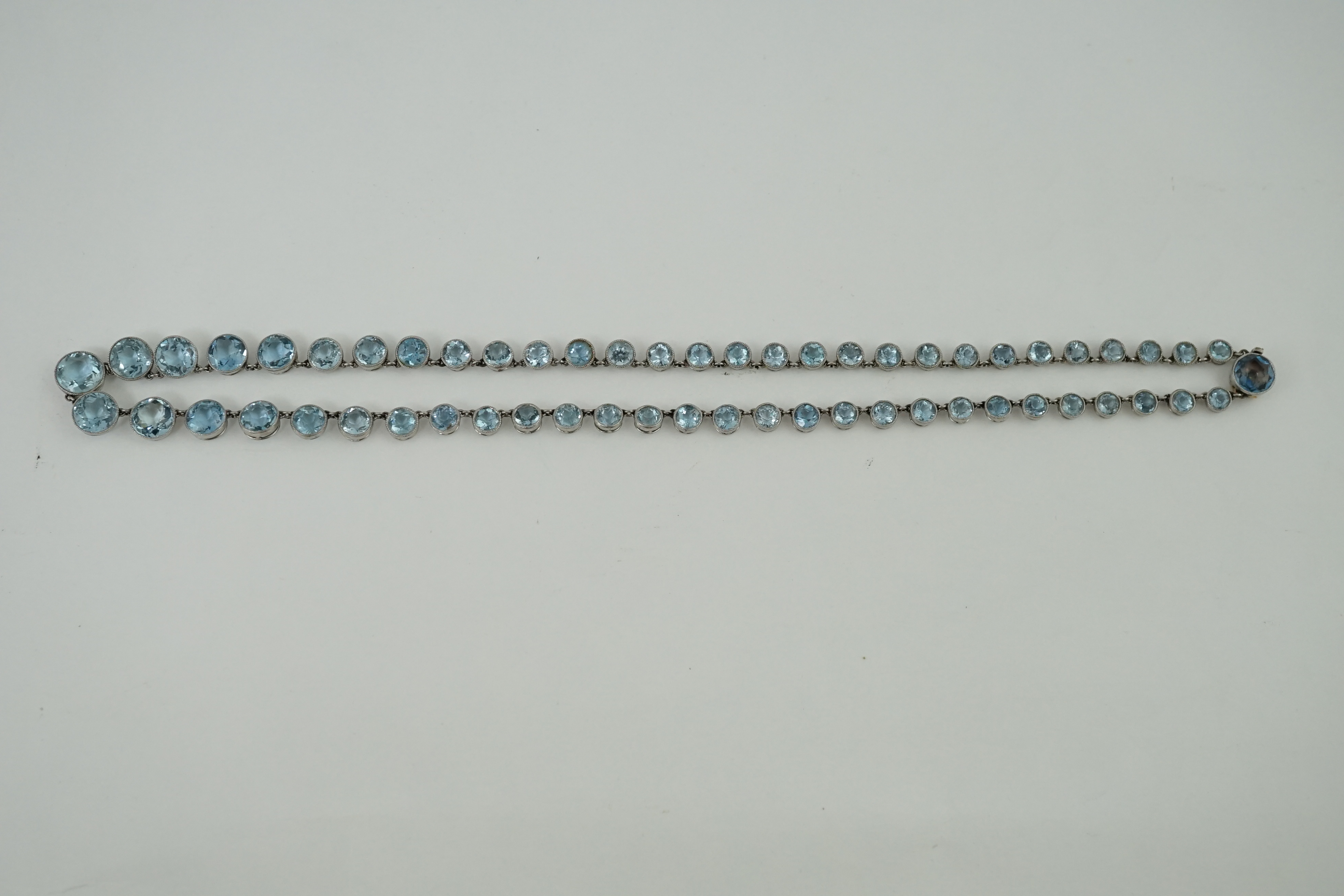 A Belle Epoque platinum and millegrain set graduated aquamarine necklace